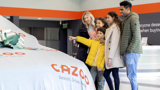 Family in showroom collecting their new car